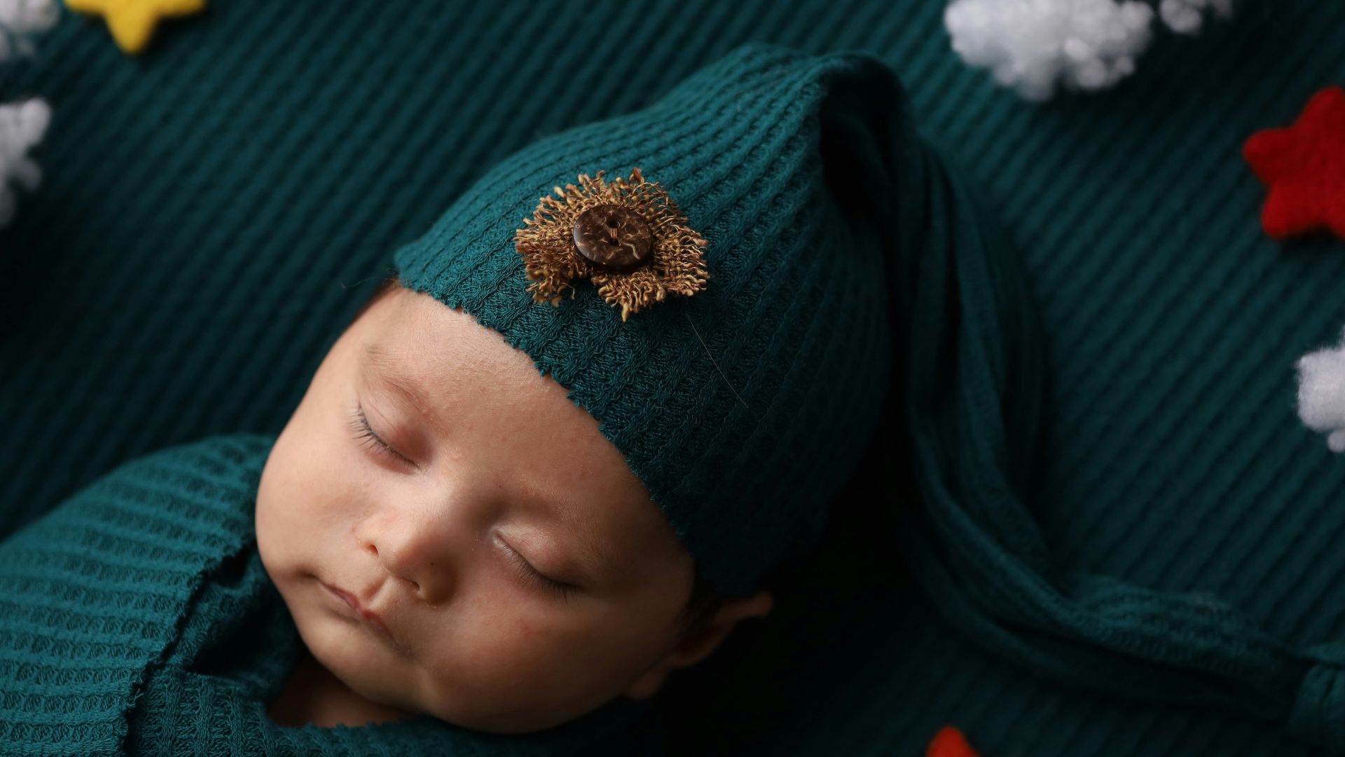 a newborn baby wearing a green hat and green sweater