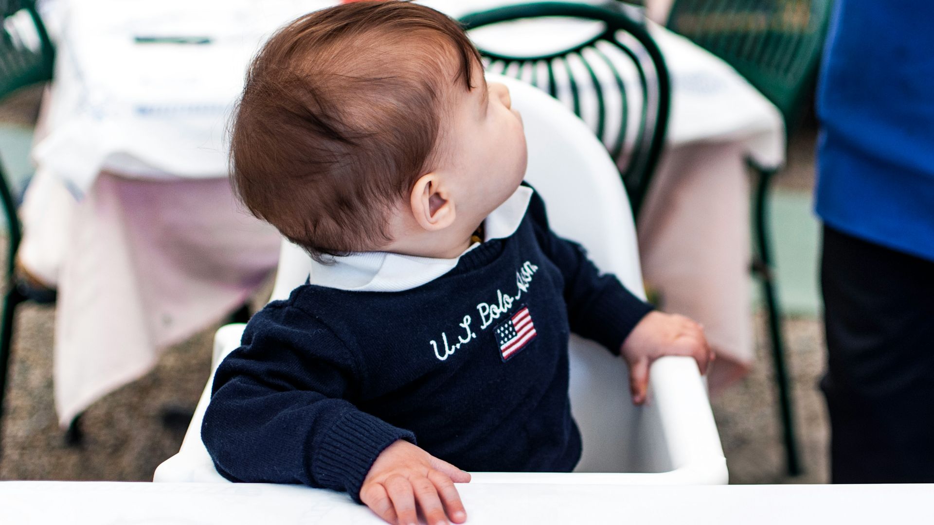 A baby sitting in a high chair at a table