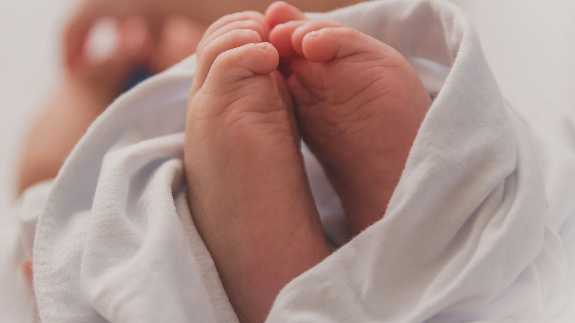 baby covered with white blanket