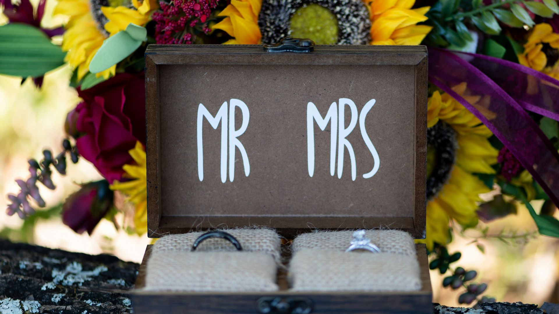 a bouquet of sunflowers and other flowers are in a box