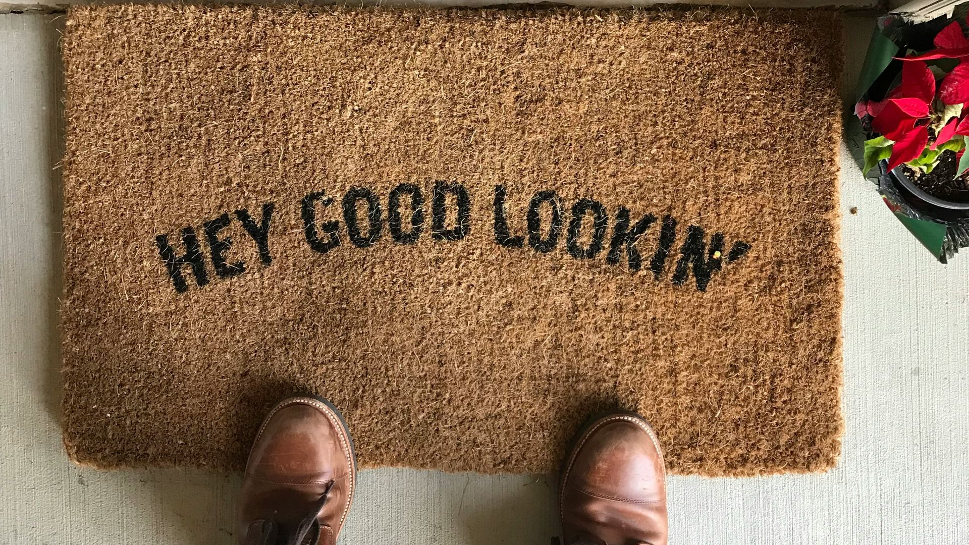 person in brown leather shoes standing on brown area rug