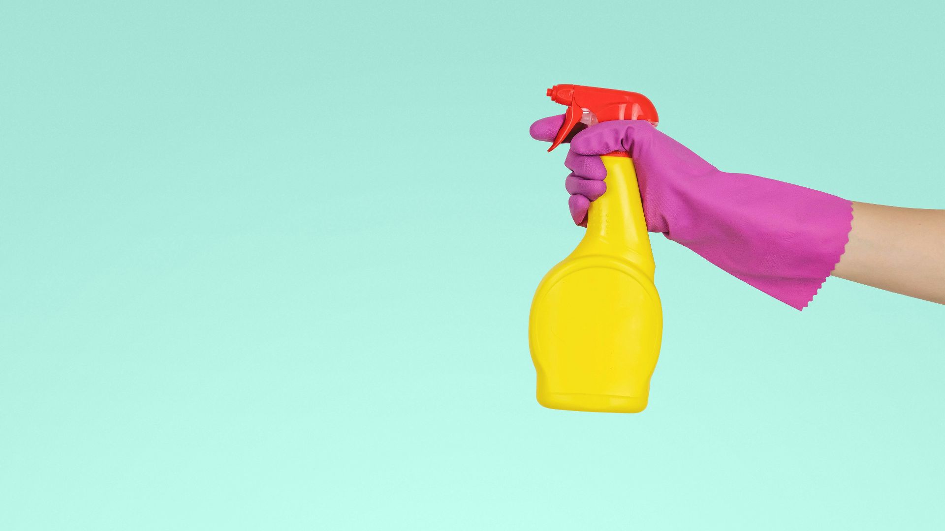 person holding yellow plastic spray bottle