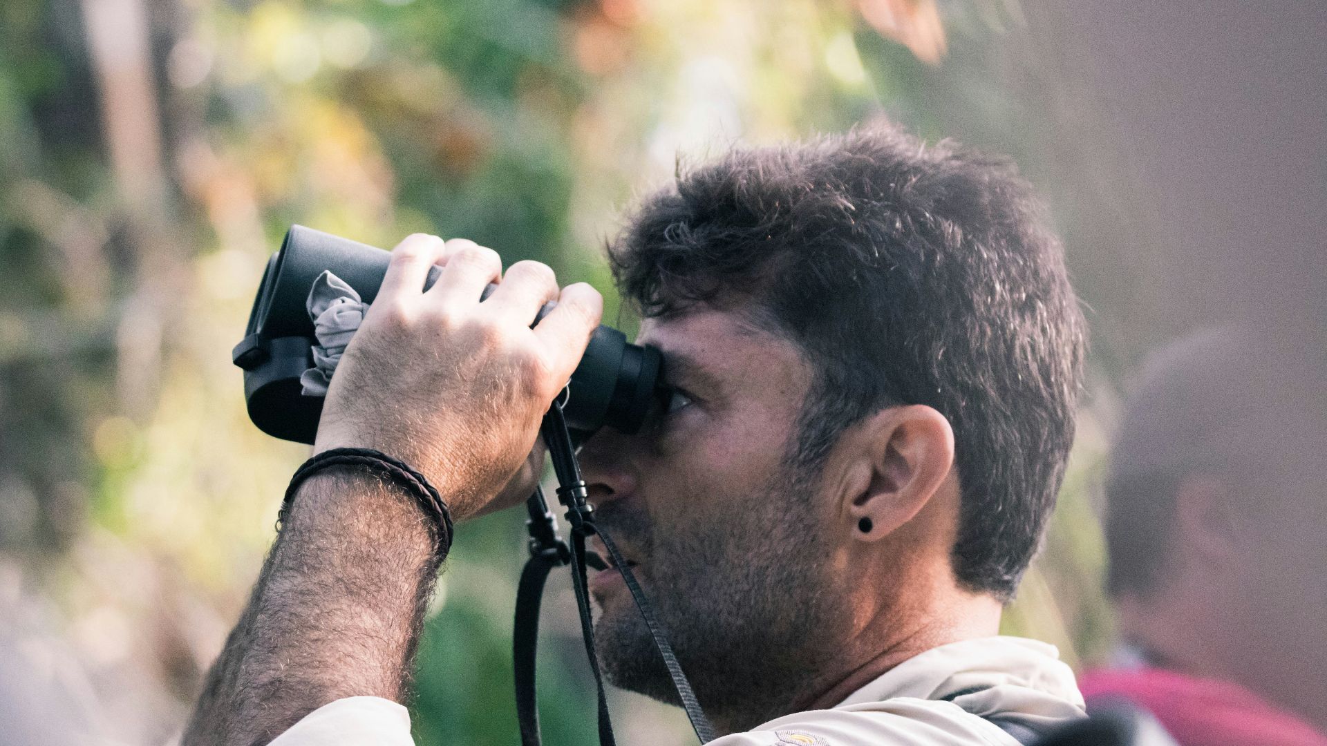 man using black binoculars at daytime