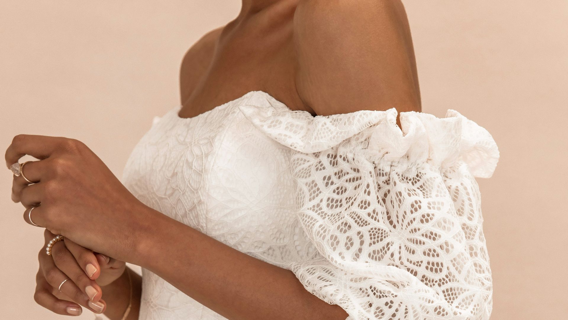 woman in white lace dress holding white bouquet
