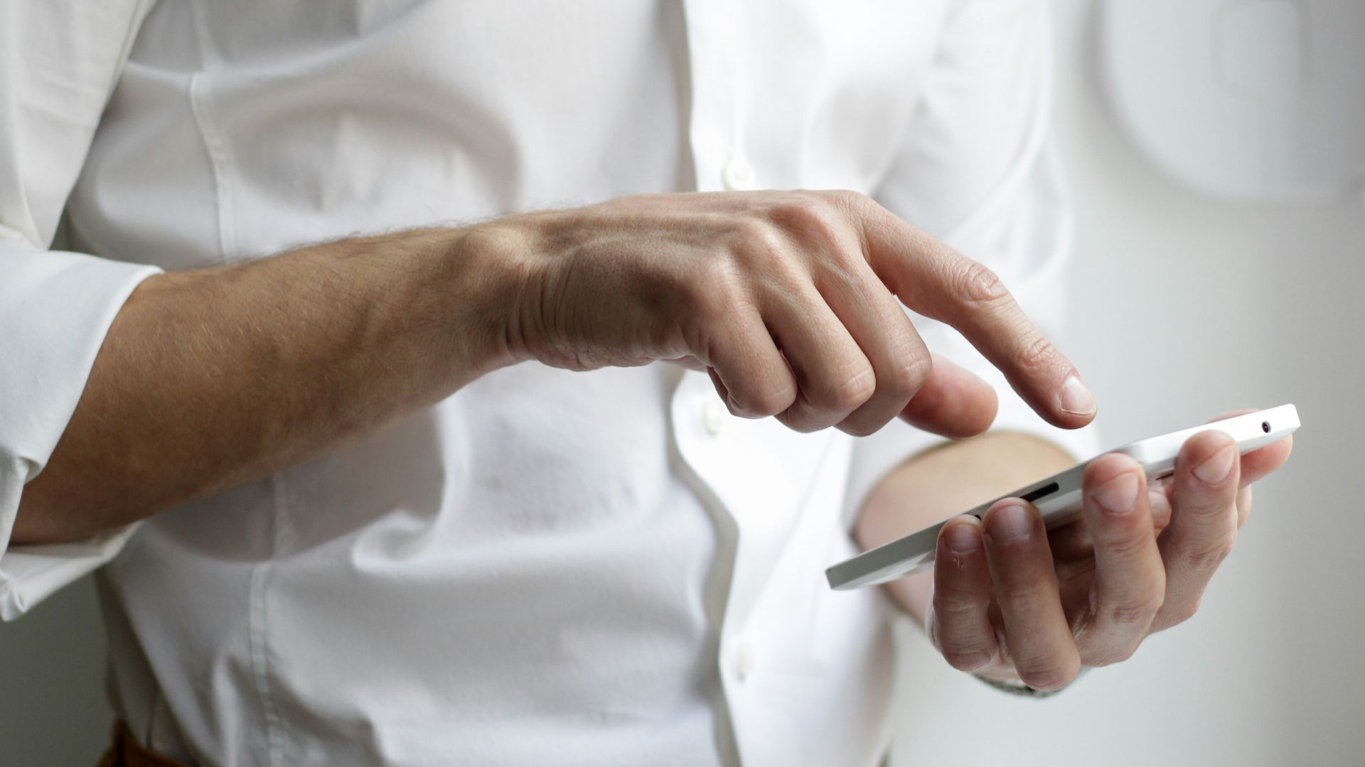 person holding white Android smartphone in white shirt