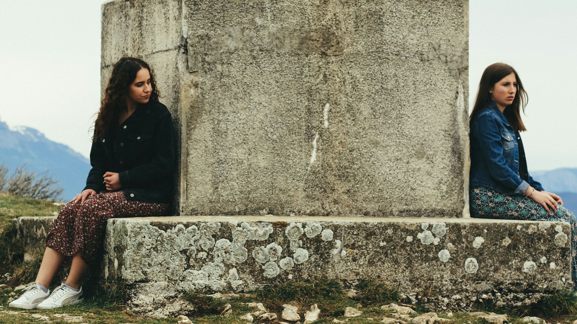 woman in black jacket sitting beside woman in black jacket