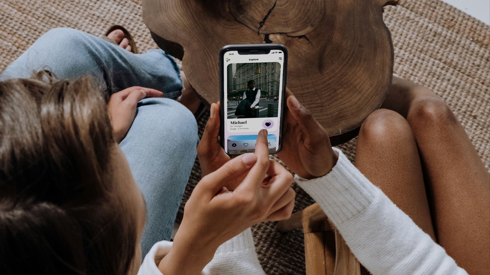 two women sitting on a couch looking at a cell phone