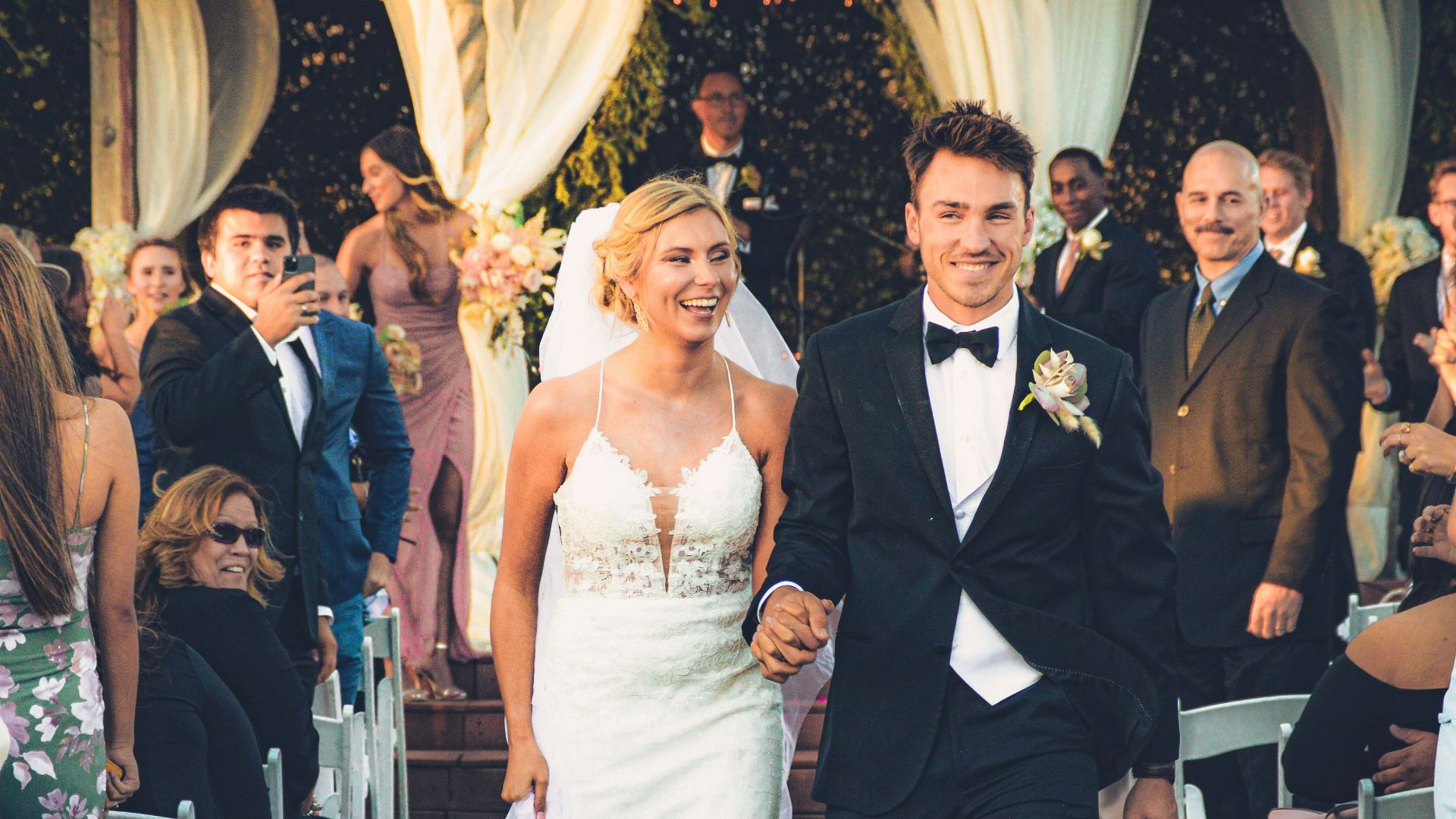 a bride and groom walking down the aisle