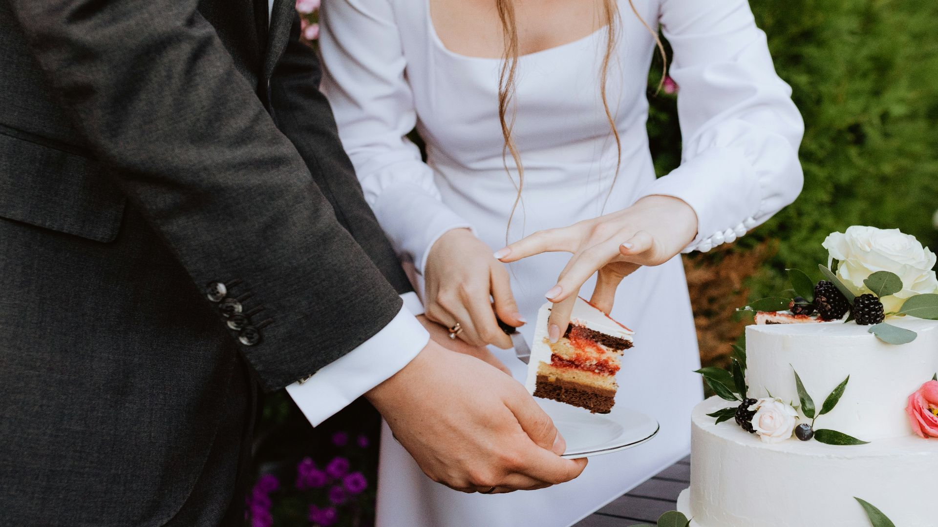 a man and a woman cutting a cake together