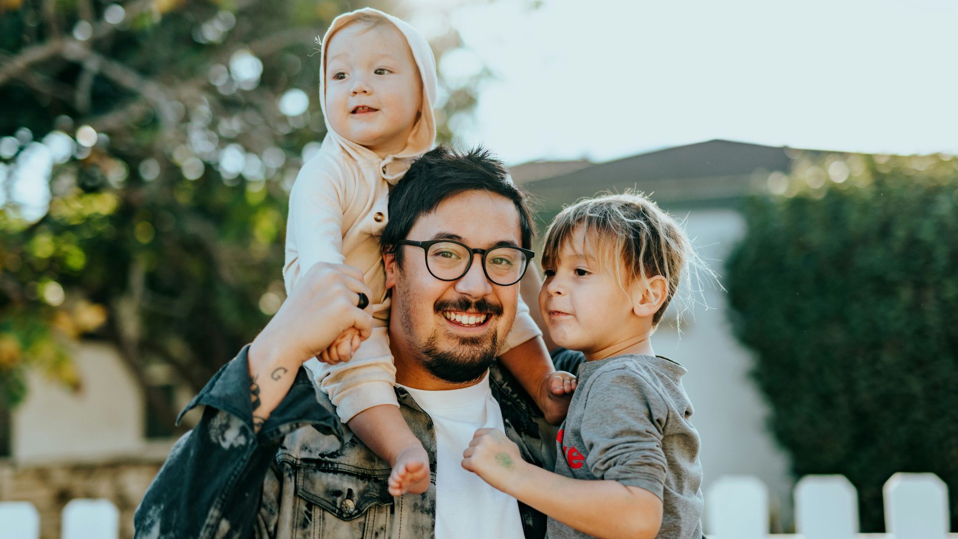 man in white shirt carrying girl in gray shirt