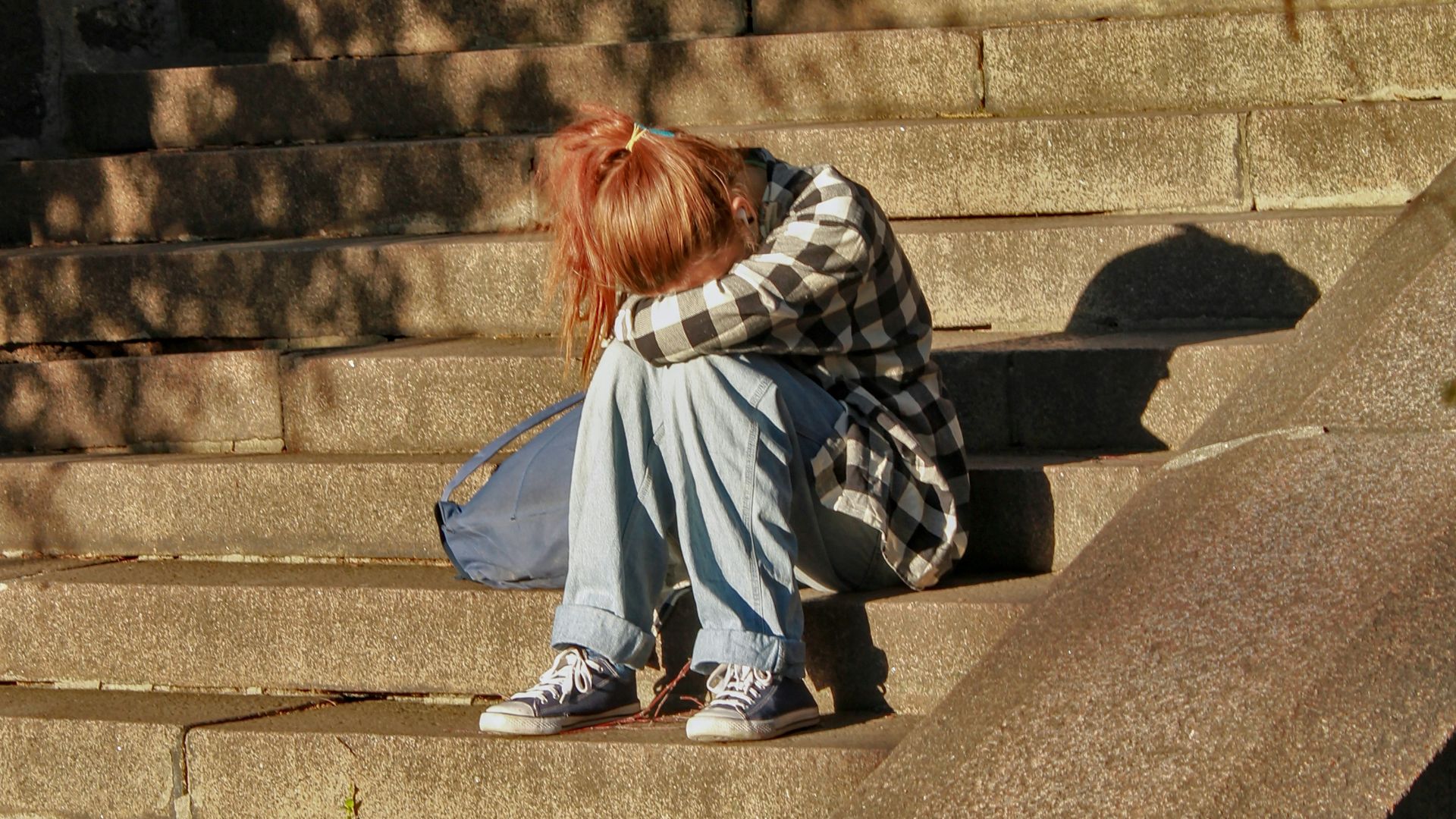woman in black and white dress sitting on concrete stairs