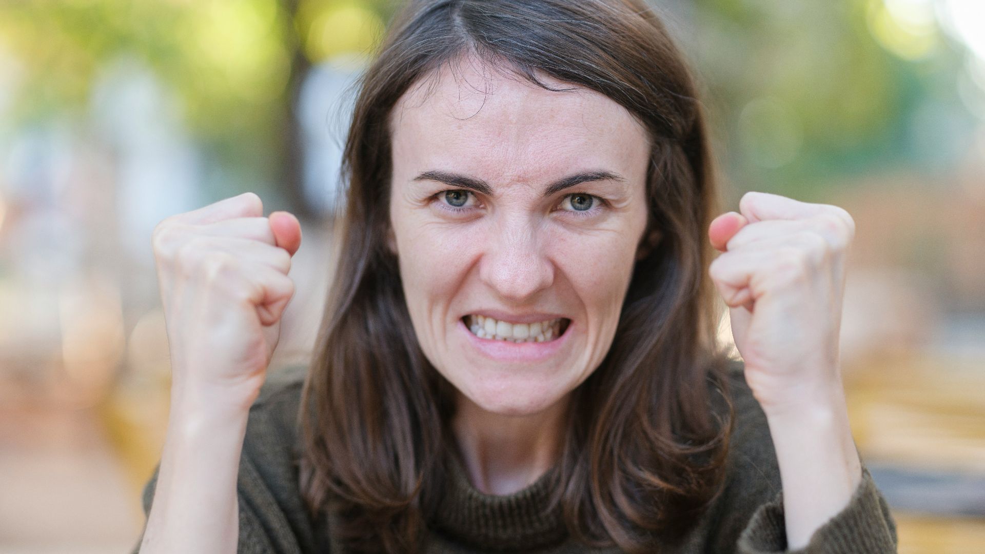a woman holding her fists up in the air