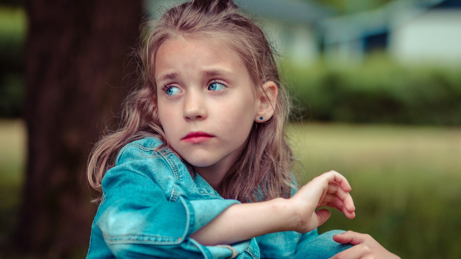 selective focus photography of girl sitting near tree