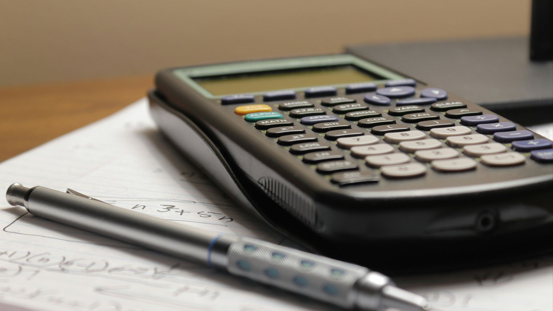 a calculator and a pen sitting on top of a piece of paper
