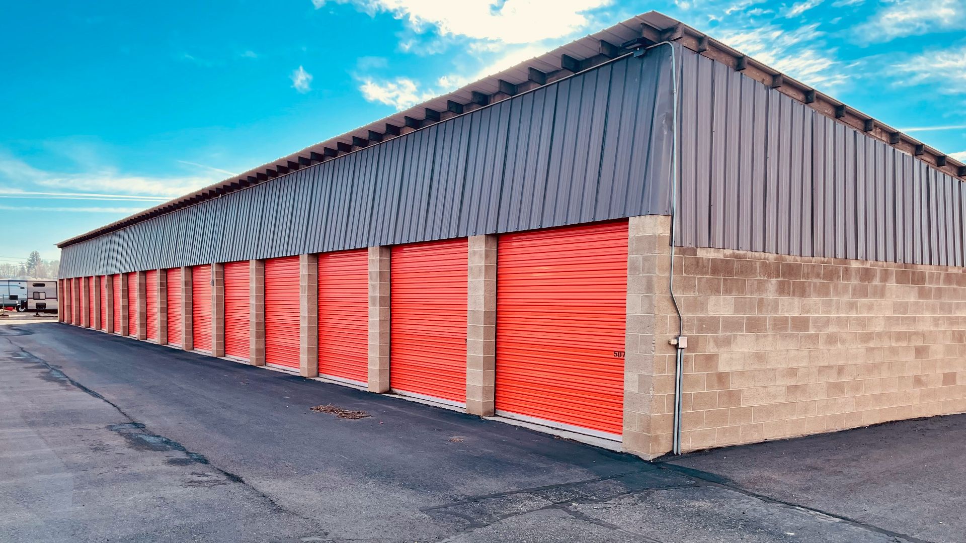 a storage building with red doors and a sky background