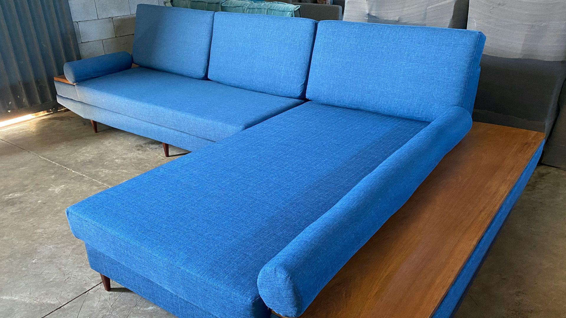 a blue couch sitting on top of a wooden table