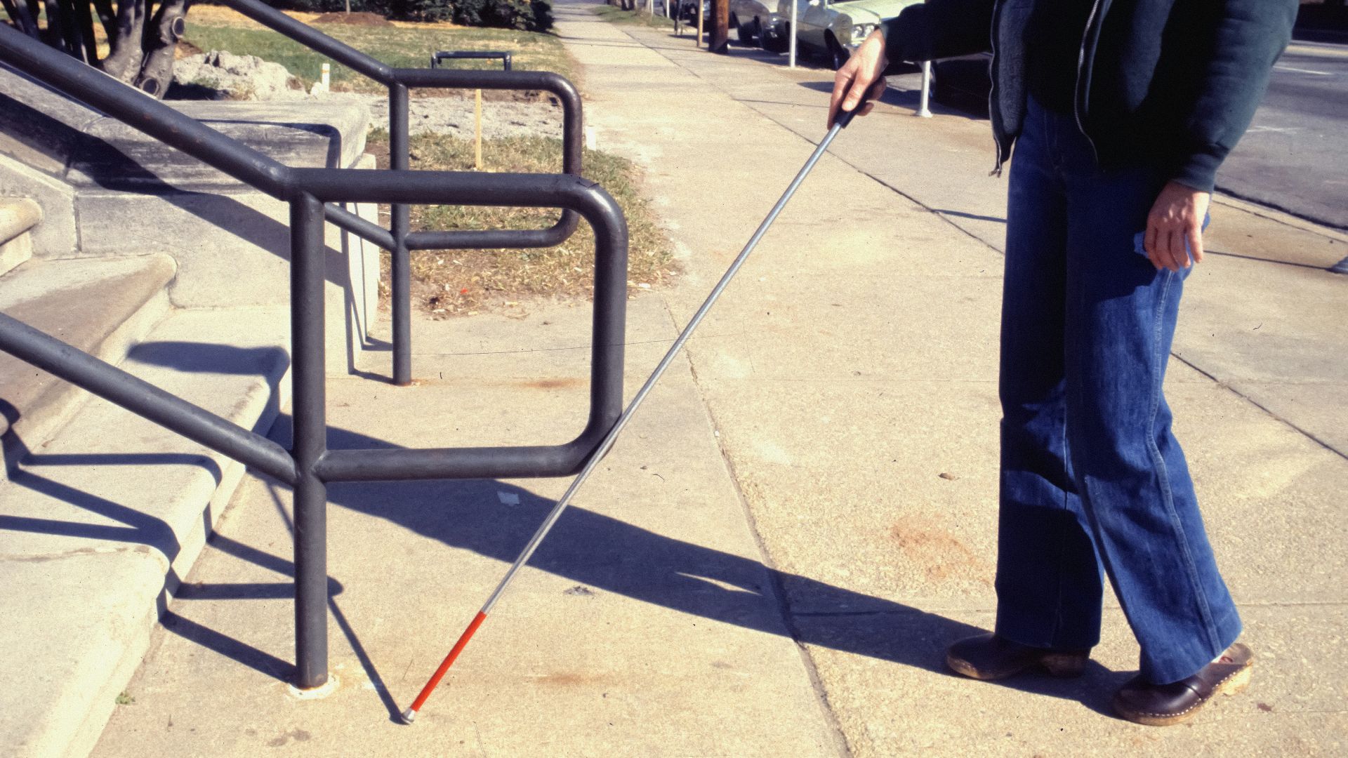 a man walking a dog on a leash down a sidewalk