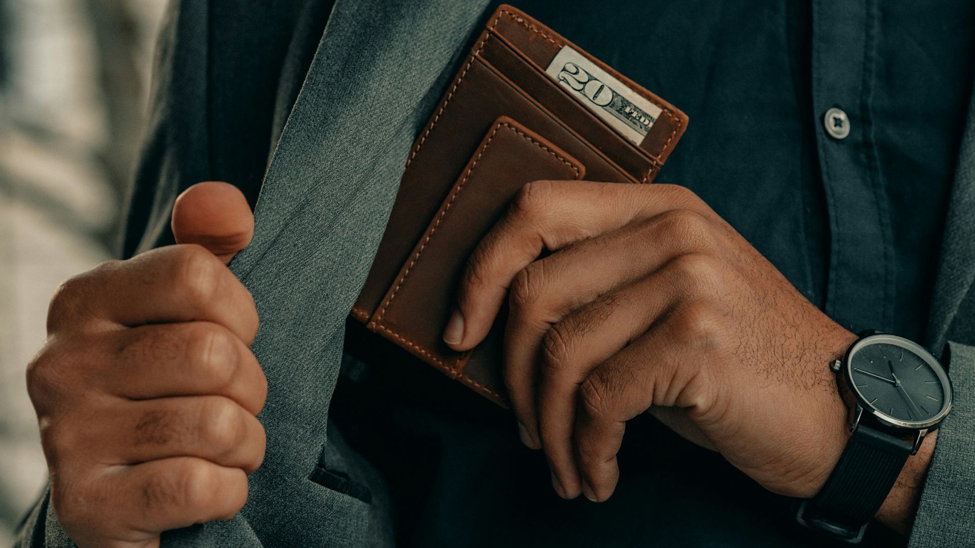 a man holding a wallet and a watch