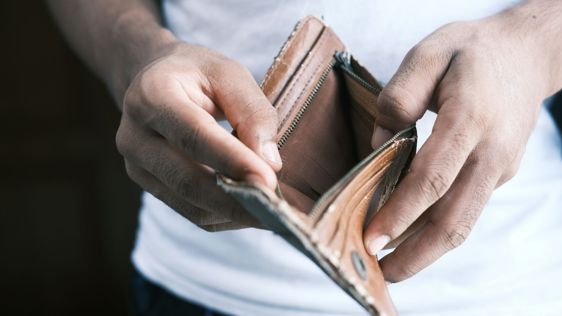 person holding brown leather bifold wallet