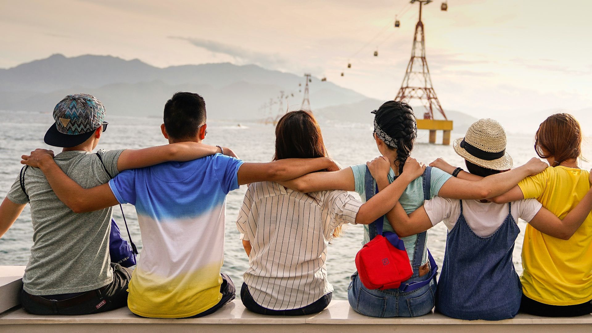 people holding shoulders sitting on wall