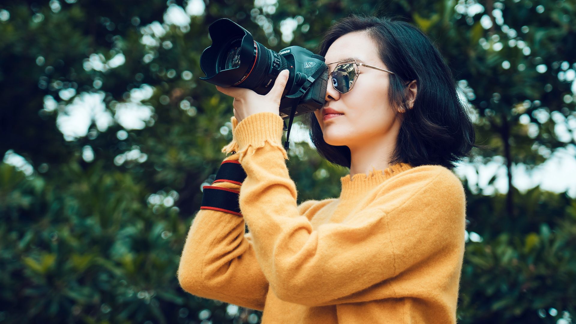 woman taking photo near tree
