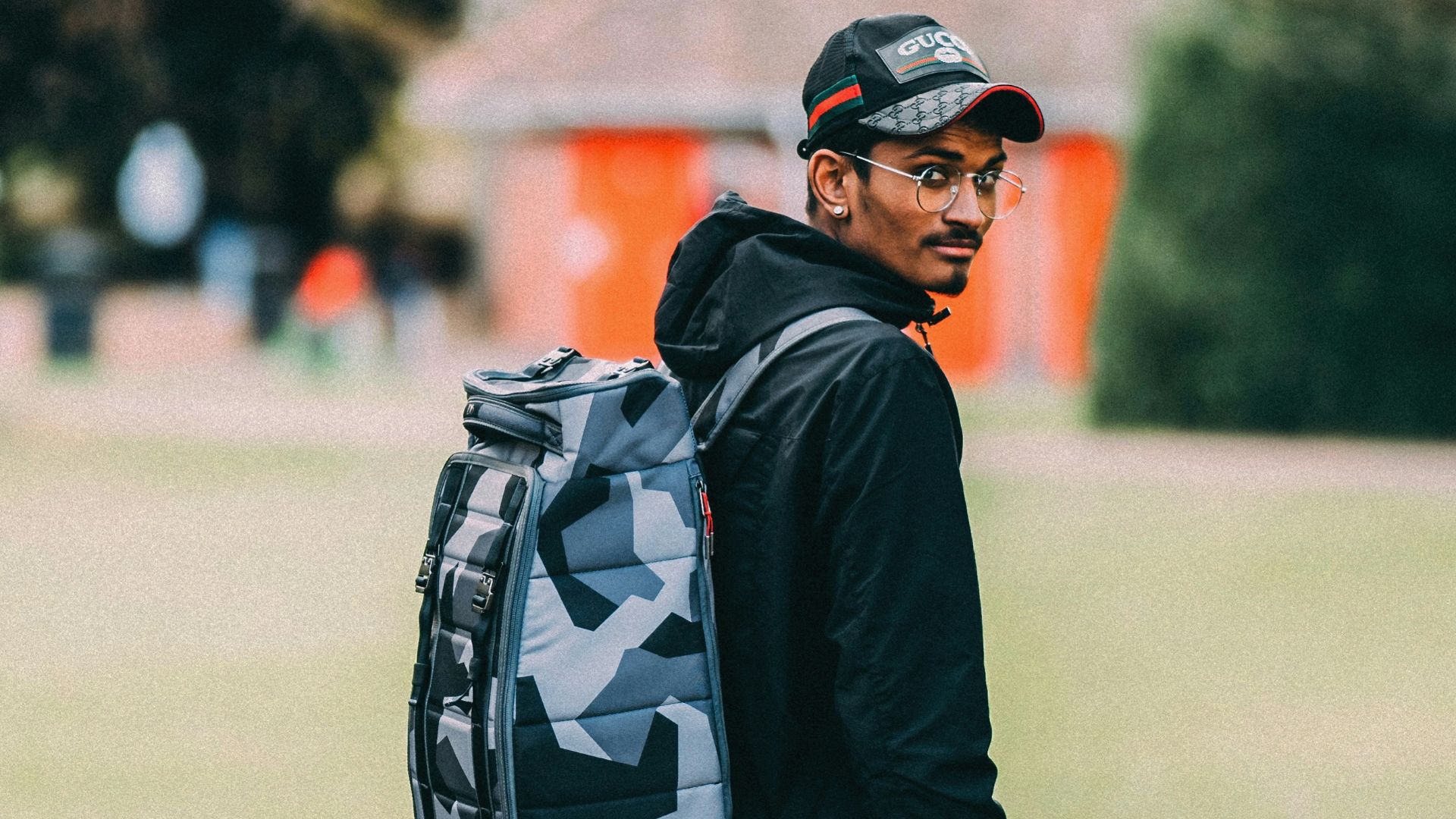 man in black jacket and black pants with black backpack walking on pathway during daytime