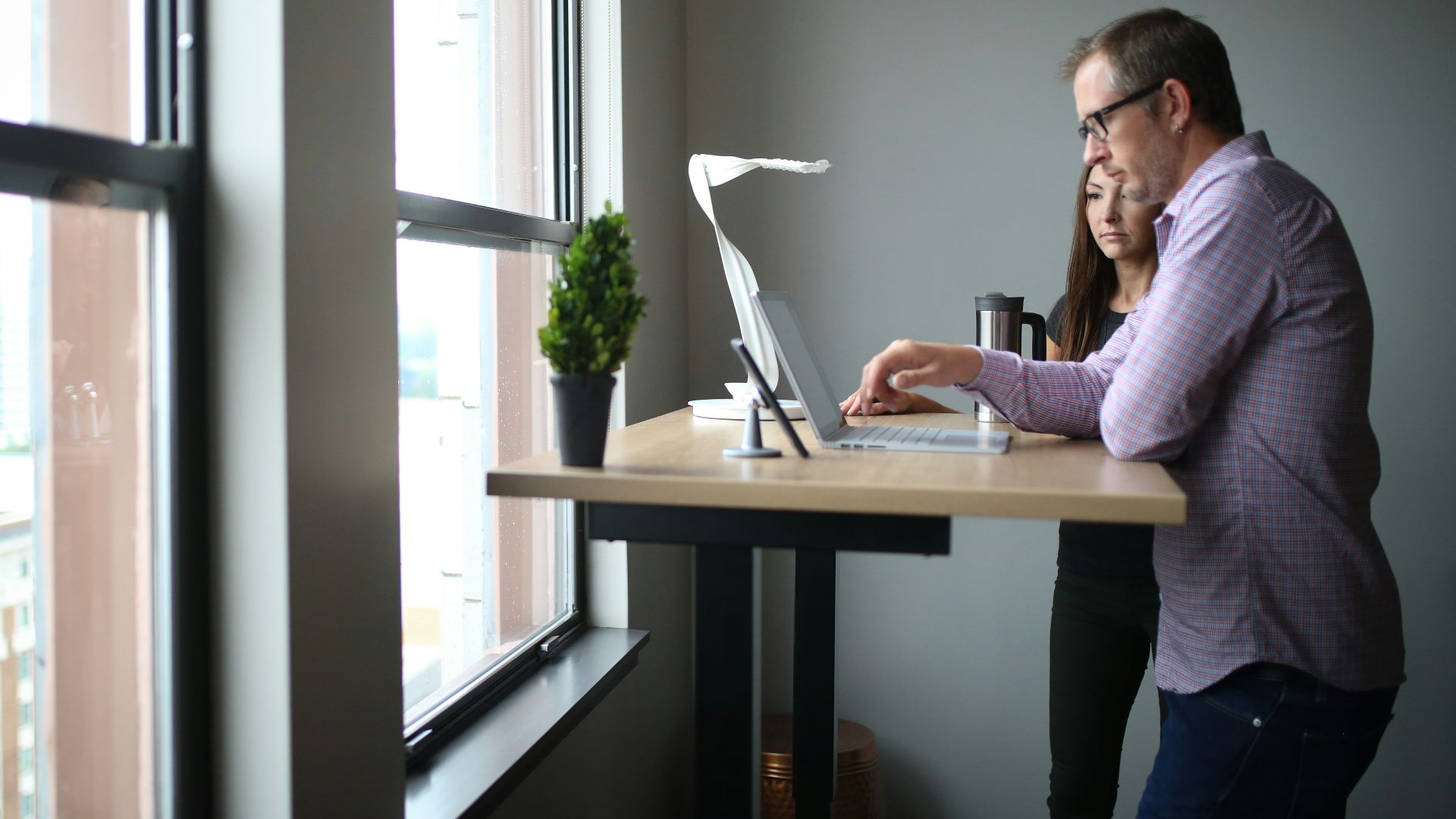 woman in pink long sleeve shirt sitting by the table