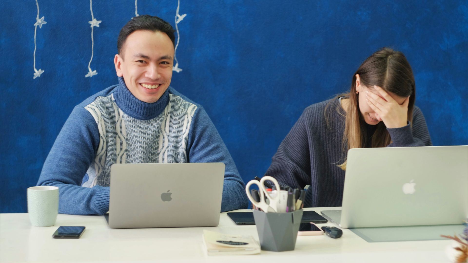 woman in gray sweater using silver macbook
