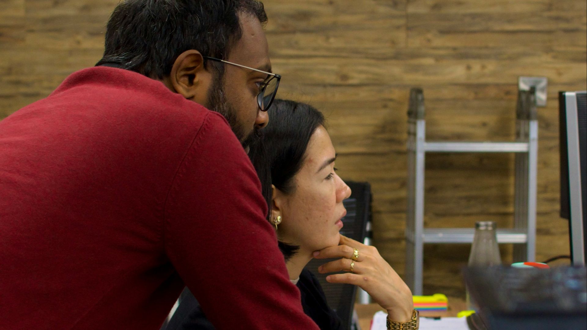 a man and a woman sitting in front of a computer