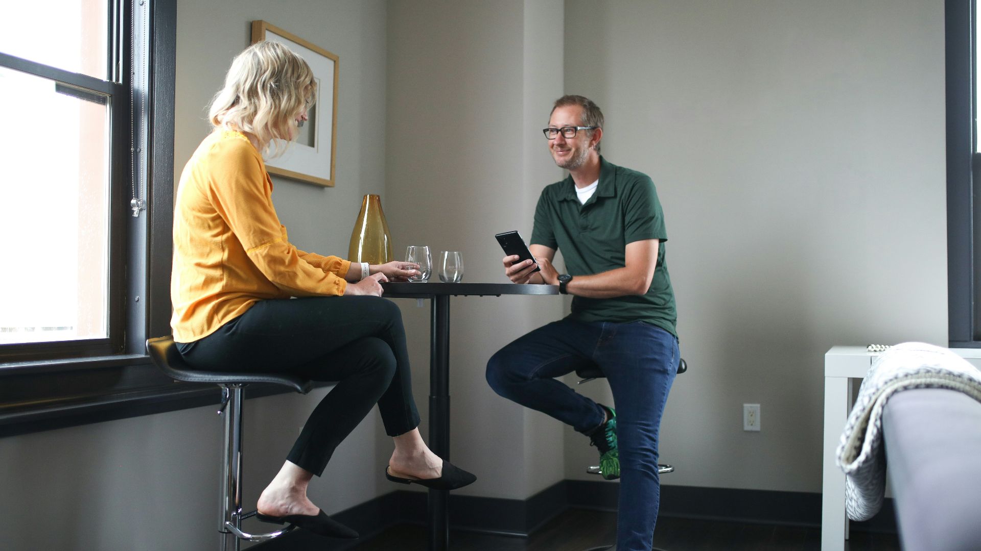 man in green polo shirt sitting beside woman in yellow shirt