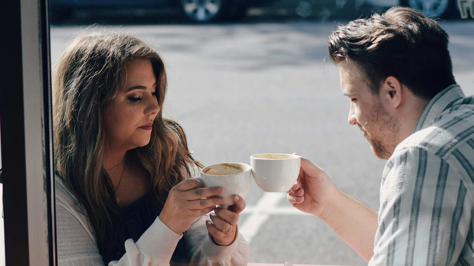 a man and a woman sitting at a table with coffee