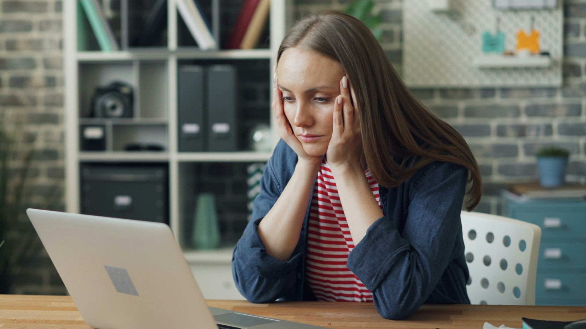 a woman sitting at a table with a laptop in front of her