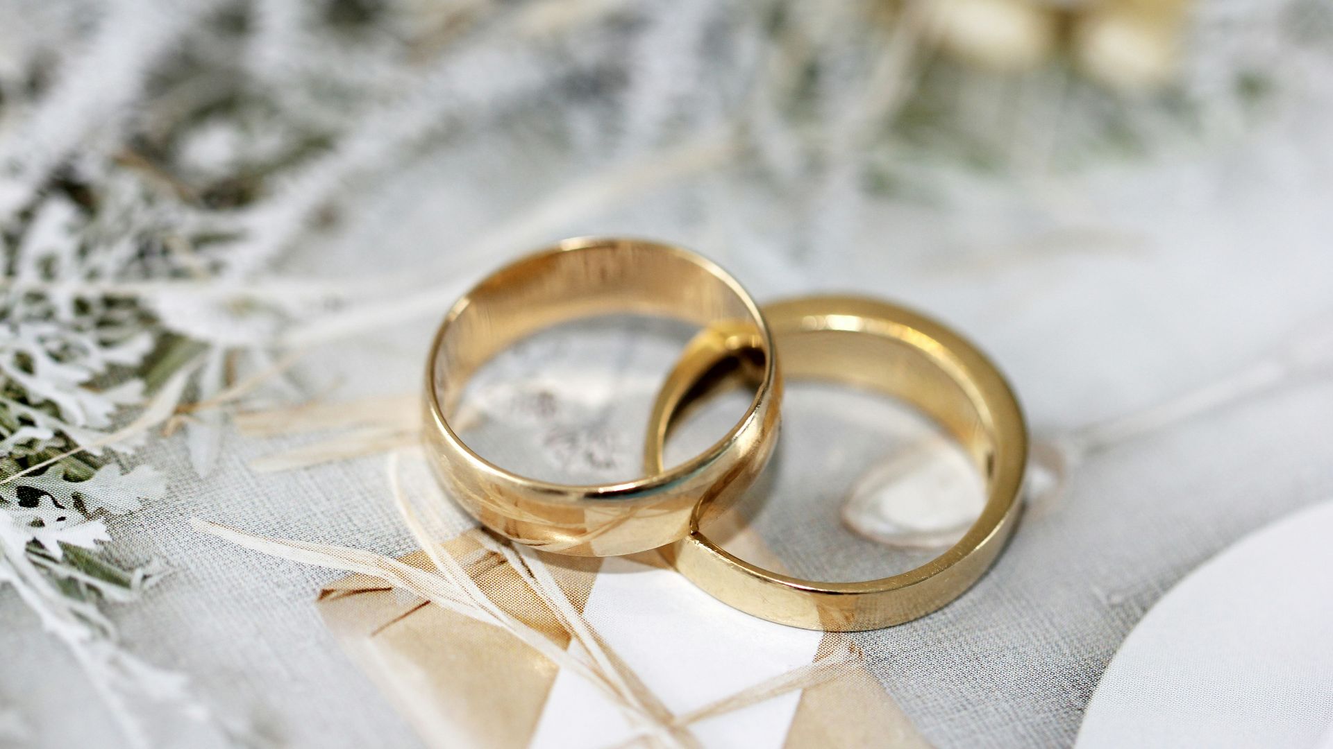 gold wedding band on white textile