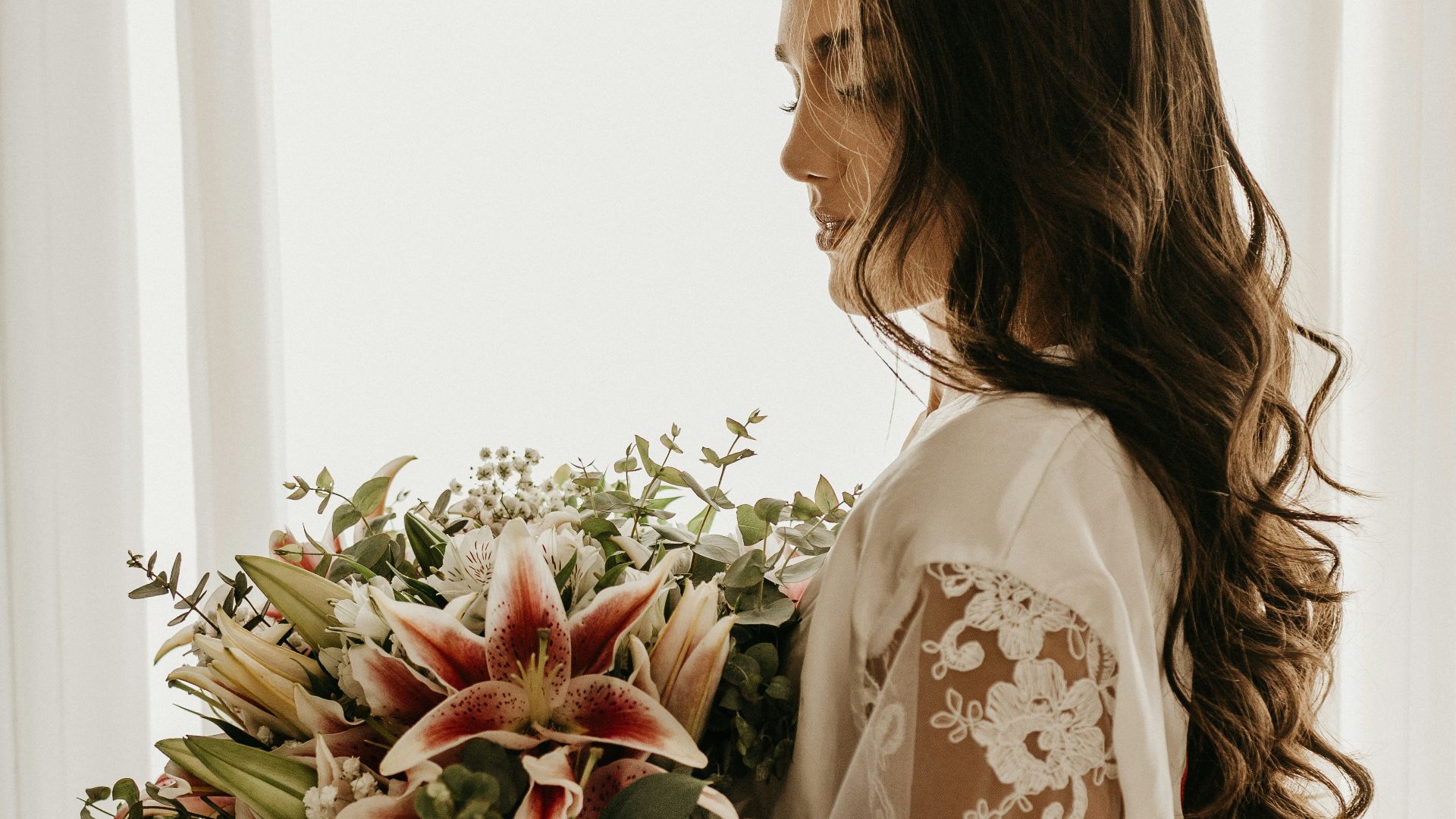 woman in white dress holding bouquet of flowers