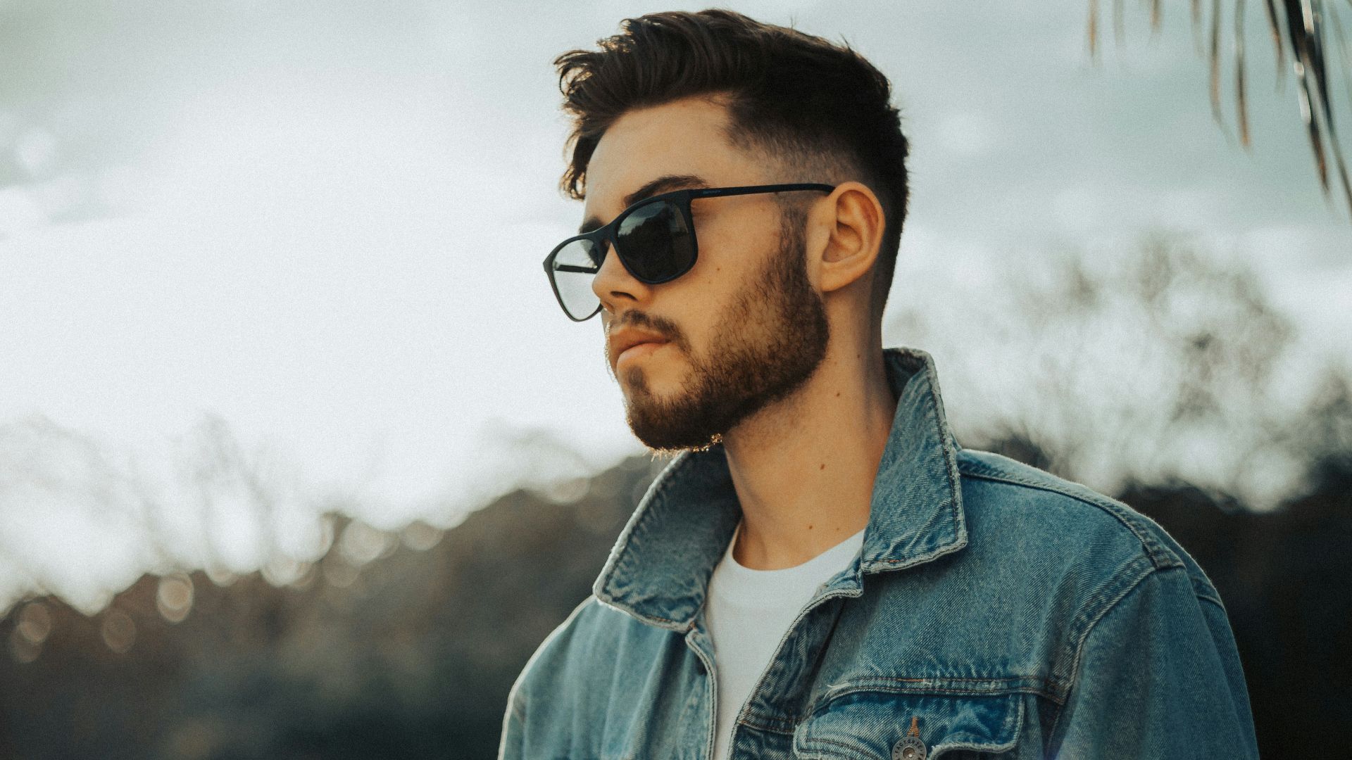 man in blue denim jacket wearing black sunglasses