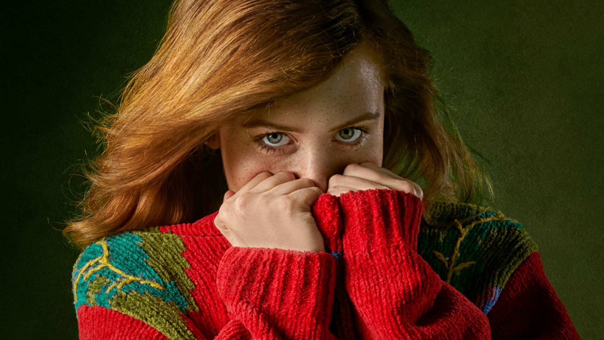 woman covering mouth with sweater