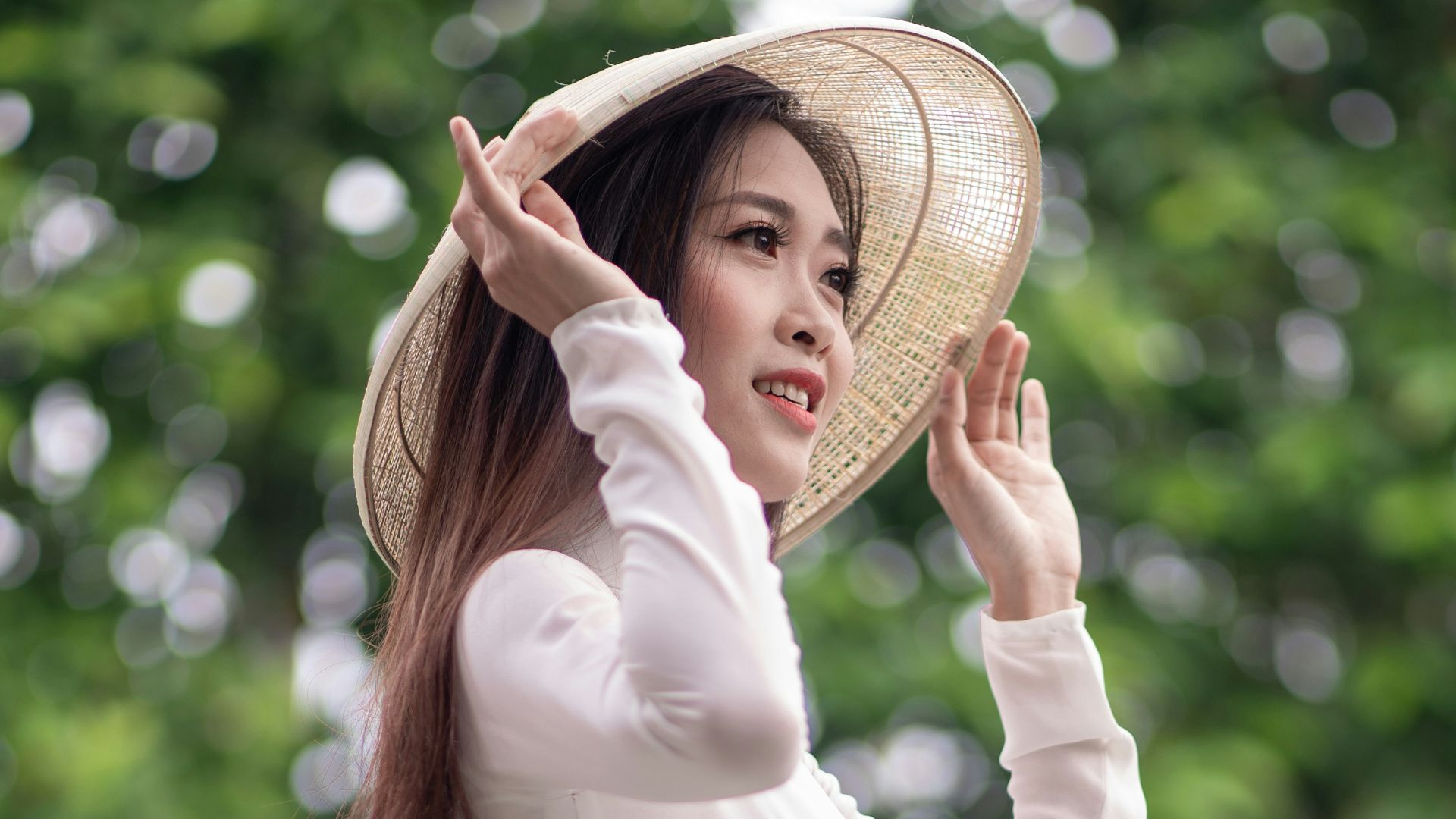 woman wearing white long-sleeved dress and beige sun hat