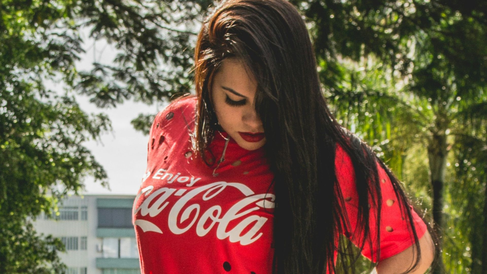 woman standing near white wooden fence looking at her shoes