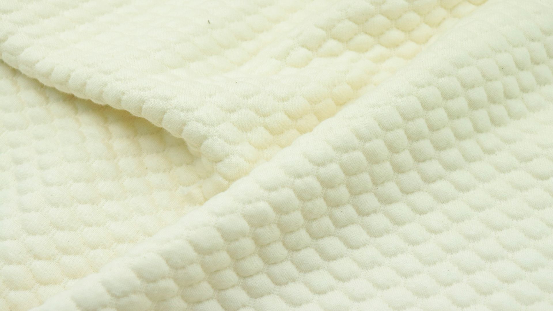 a close up of a white quilted material