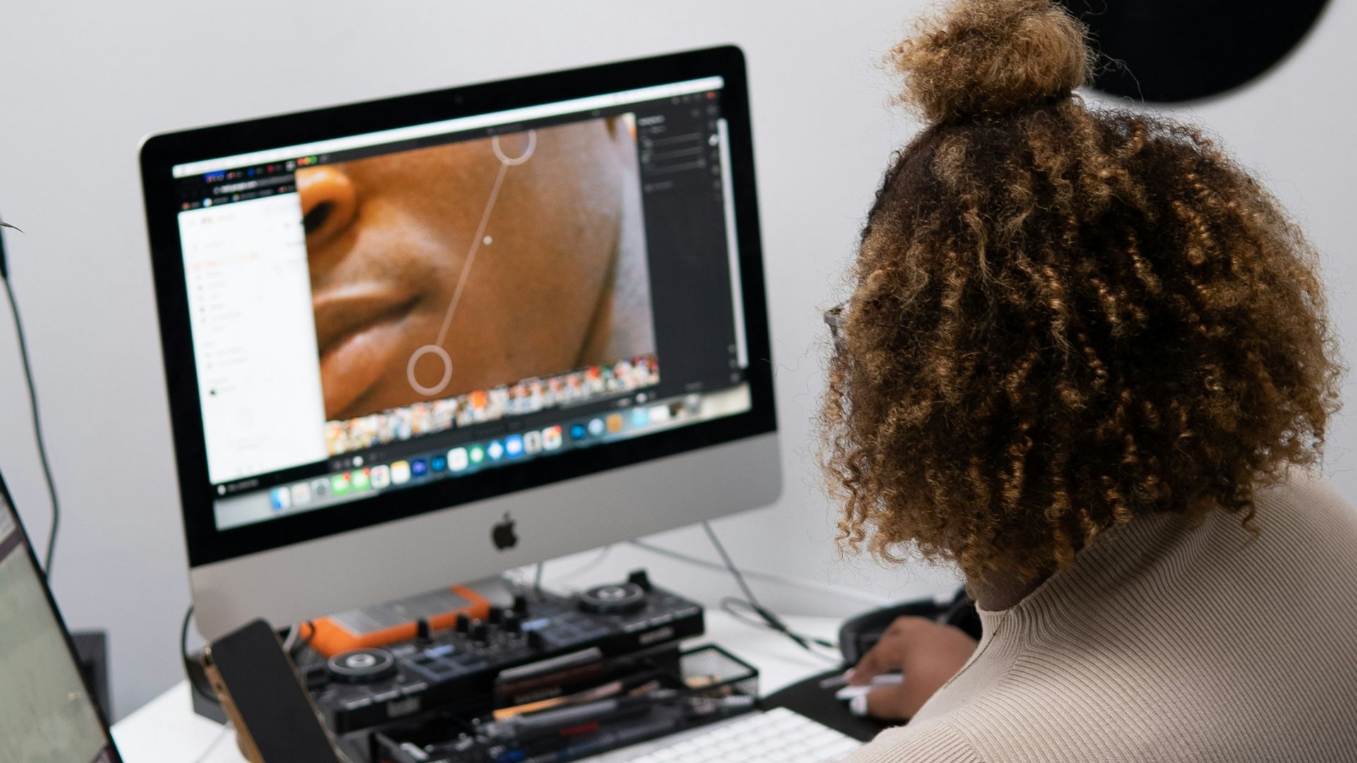 a person sitting at a desk with a computer and a stuffed animal