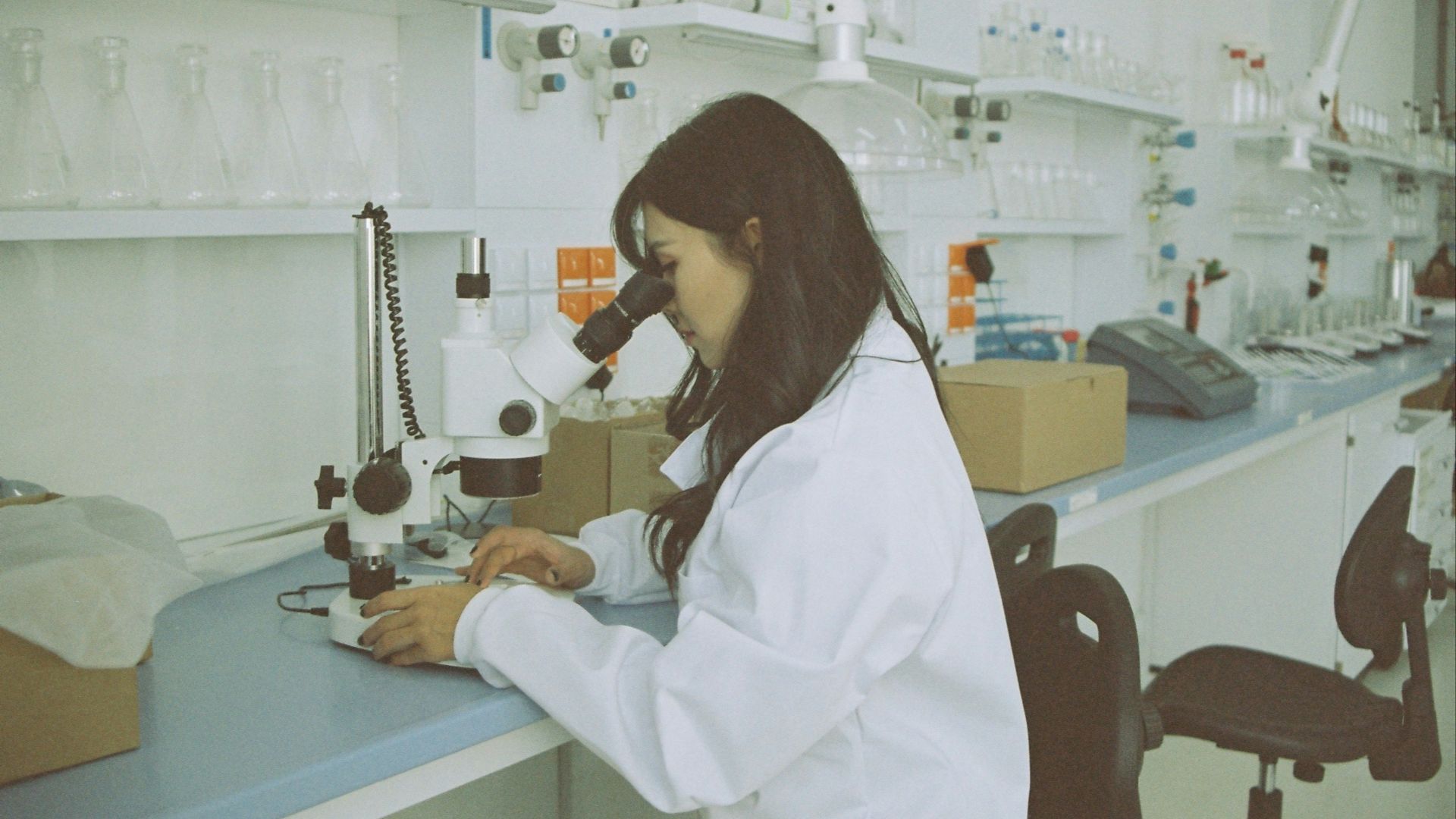 woman in white long sleeve shirt using white and black sewing machine