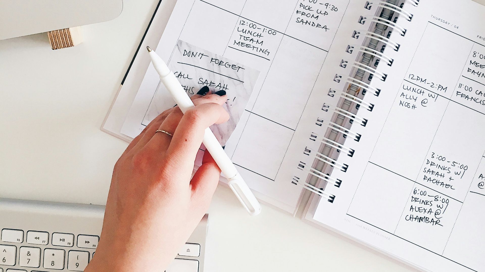 person holding notepad and pen flat lay photography