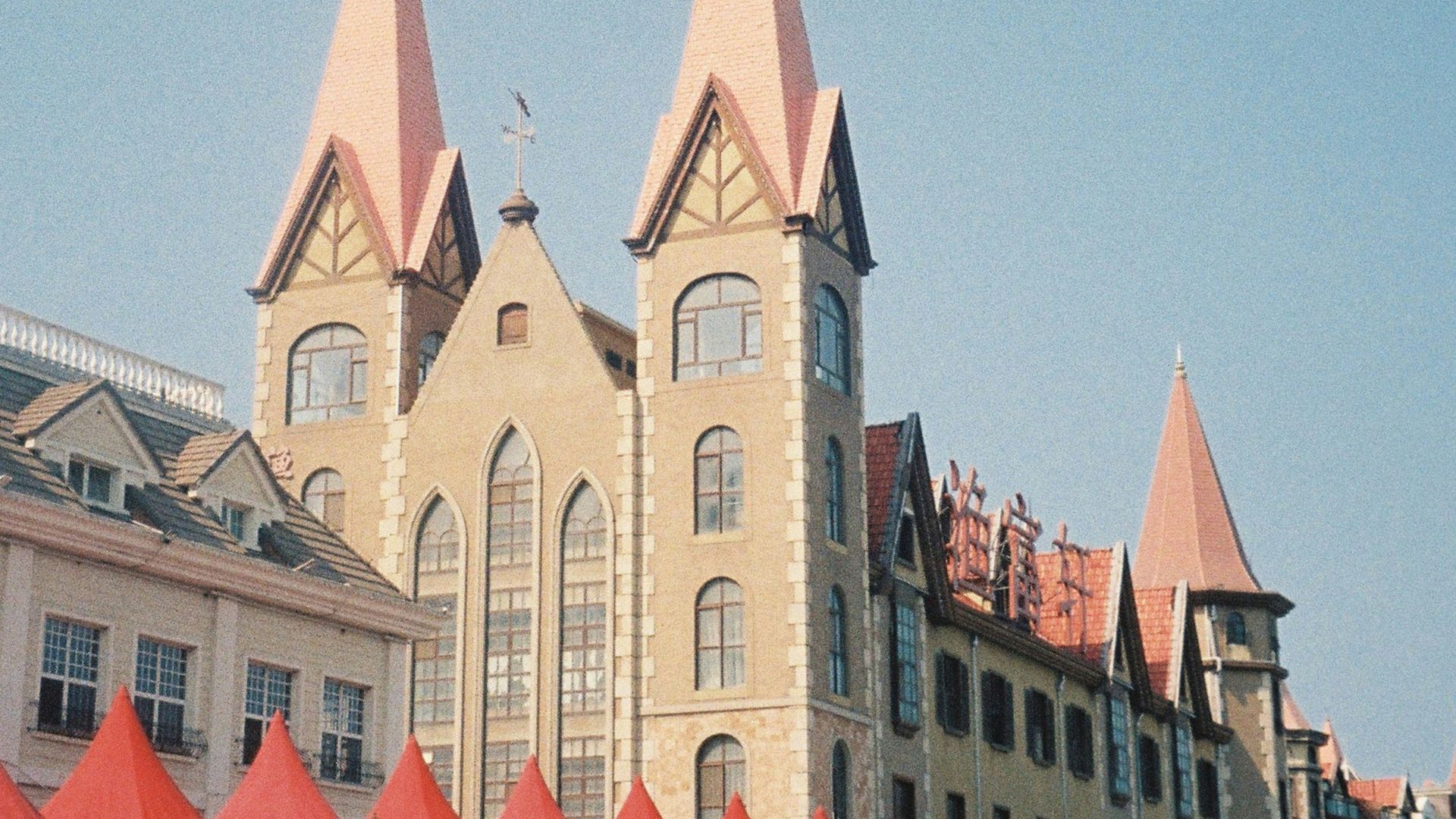 a large building with red tents in front of it