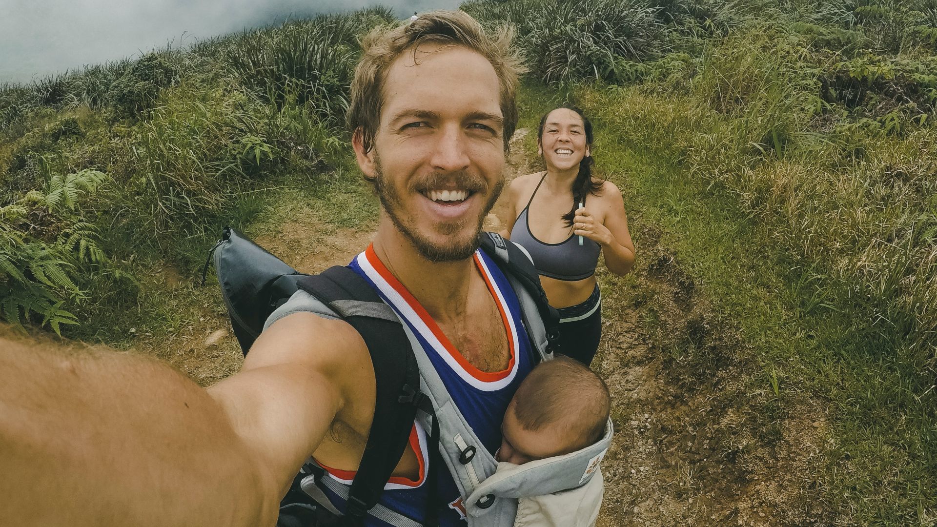 woman, man and baby taking photo surrounded grass