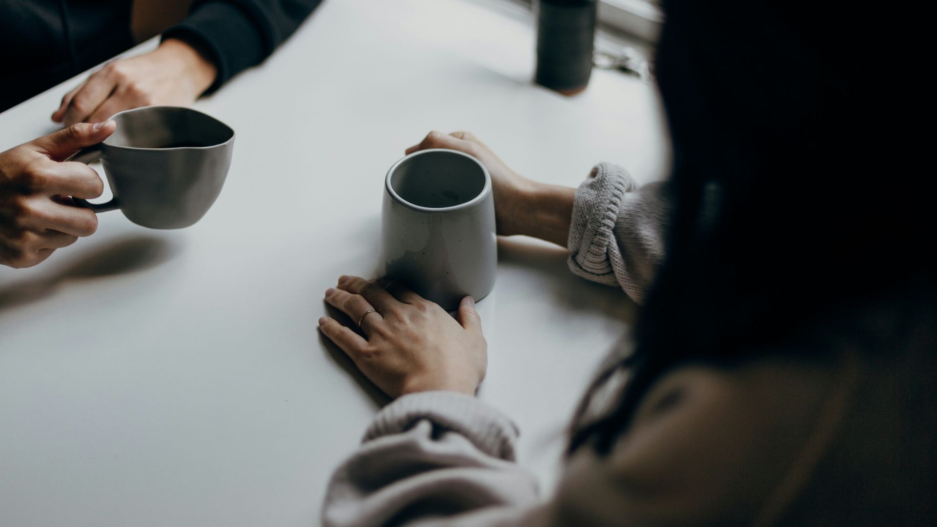 woman in black long sleeve shirt holding black ceramic mug