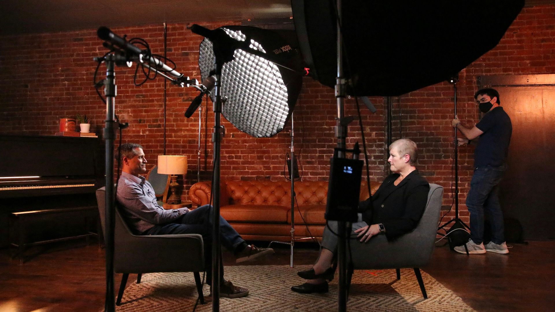 a man and a woman sitting in chairs in front of a camera