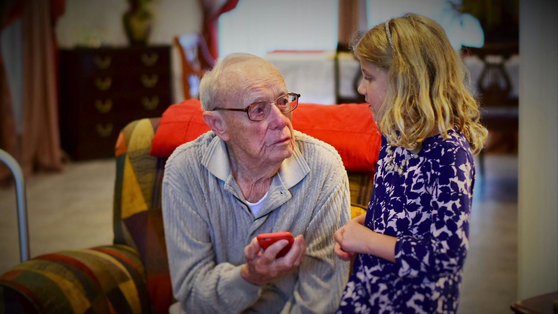 man in gray sweater sitting beside woman in black and white floral long sleeve shirt