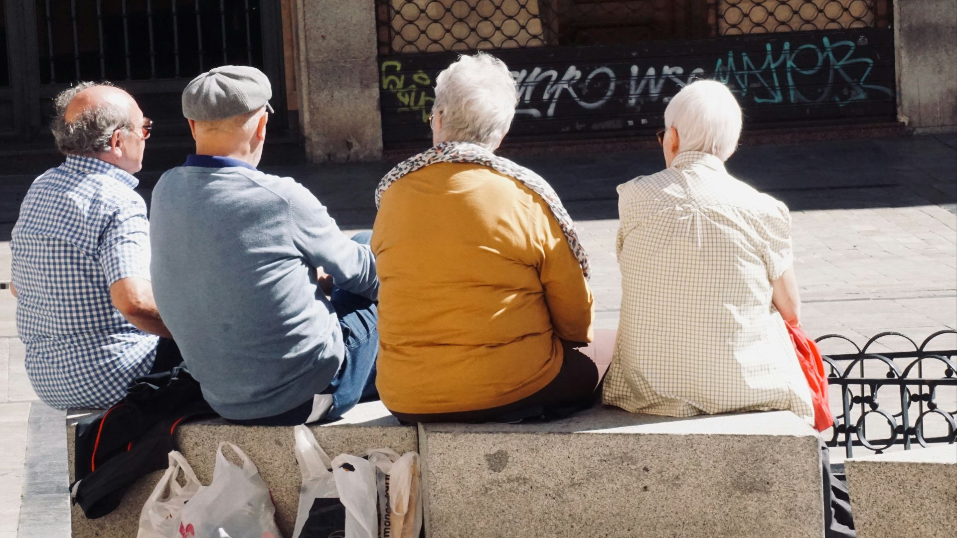 people sitting on gray concrete bench during daytime