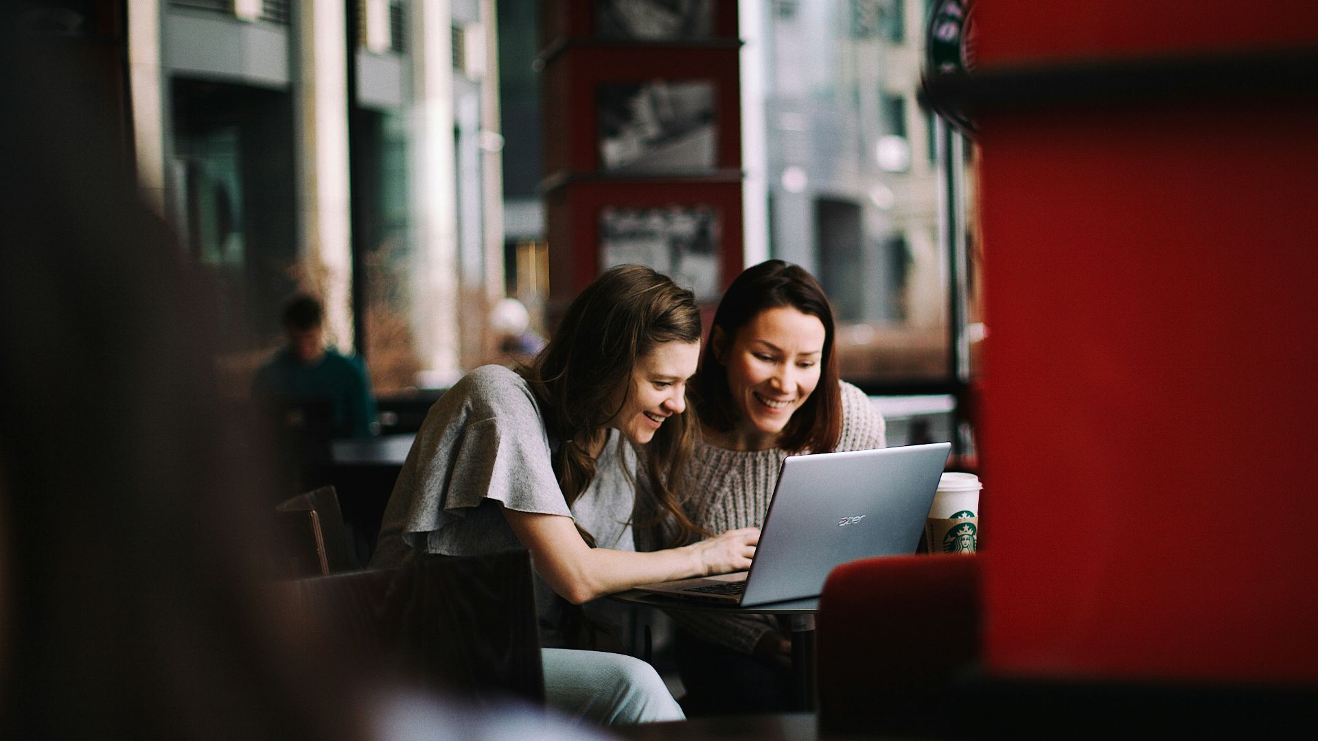 woman in white shirt using macbook