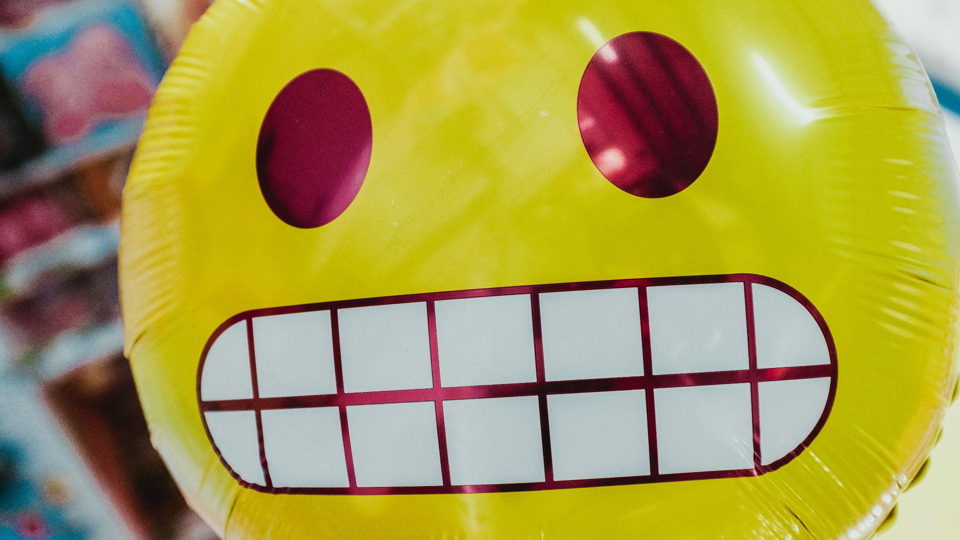 yellow inflatable smiling emoji balloon in focus photography